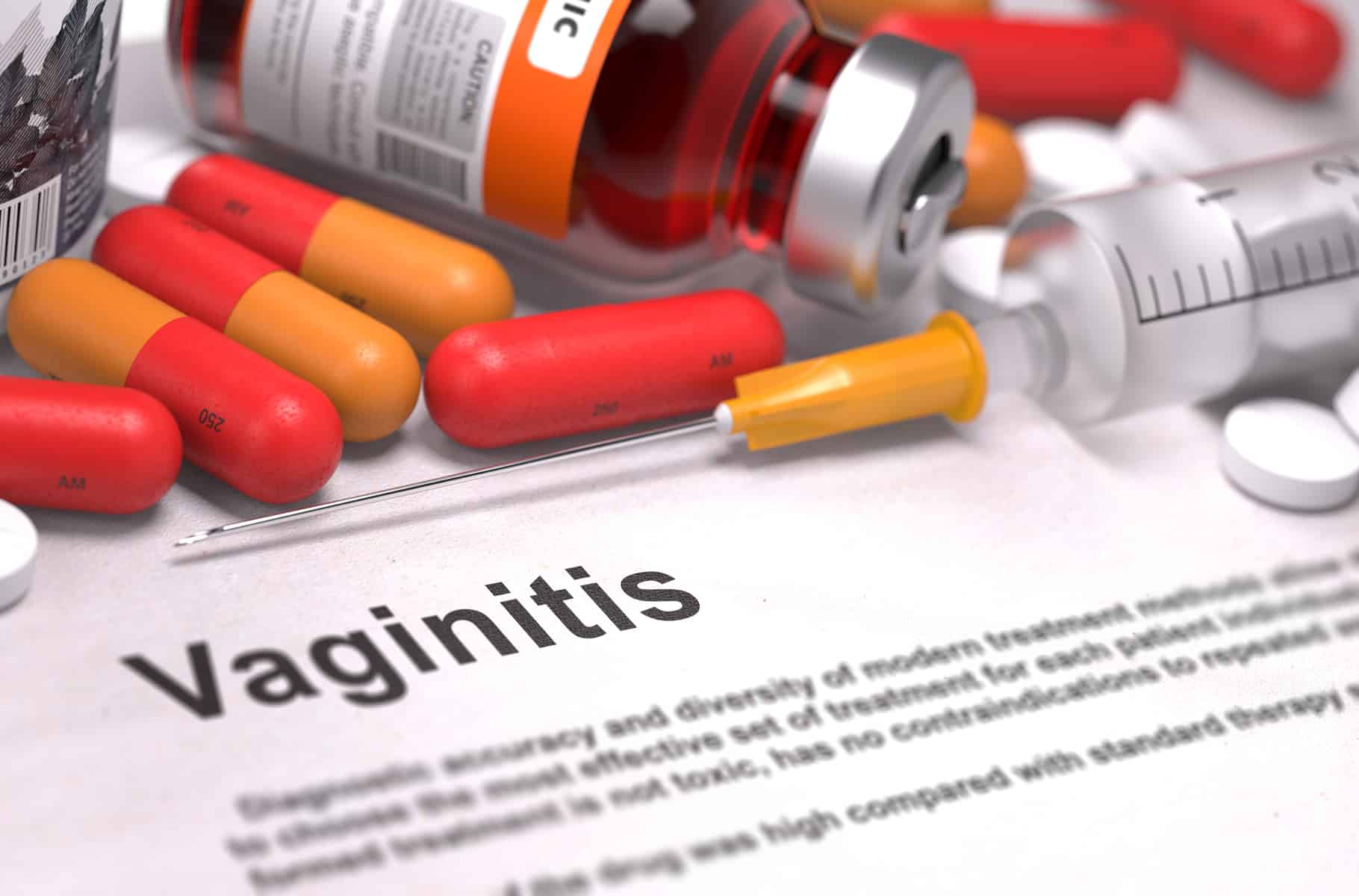 Vaginitis - Printed Diagnosis with Blurred Text. On Background of Medicaments Composition - Red Pills, Injections and Syringe.